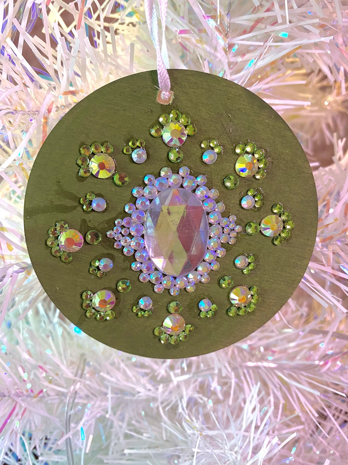 olive green ornament with multicolored glass gems and white oval center