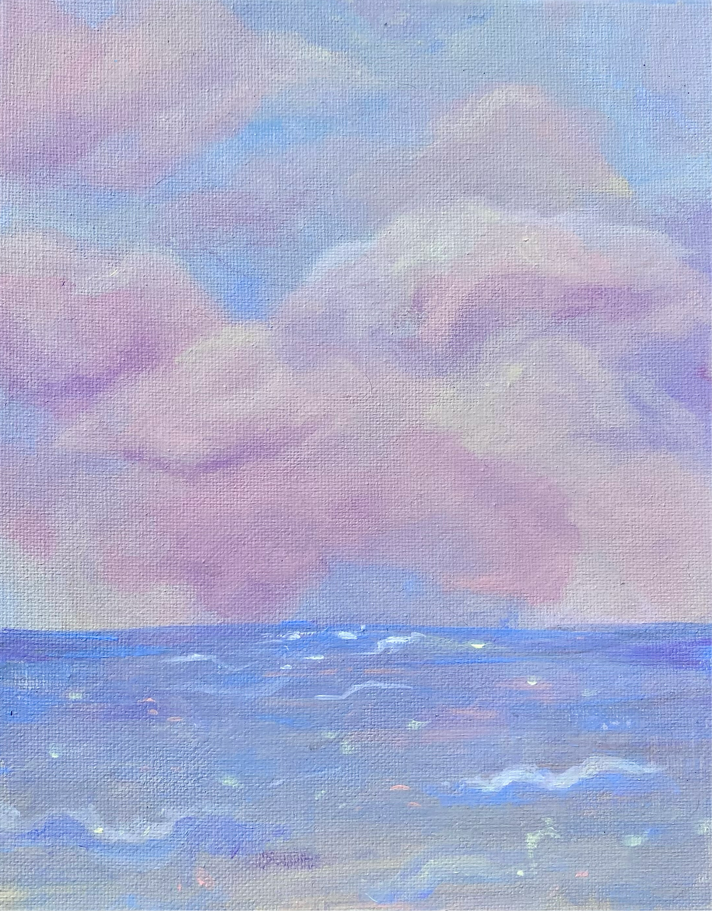 pink and white clouds over a soft blue sea