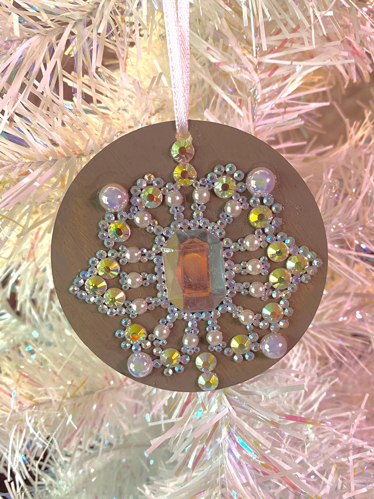 taupe round ornament with multi colored gems, rhinestones, and pearls