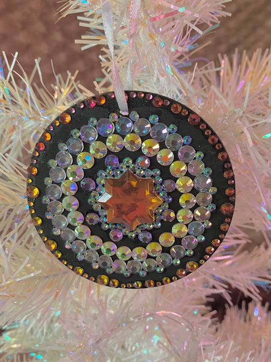 black ornament with orange and multicolored gems