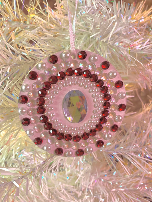 white round ornament with red and white gems