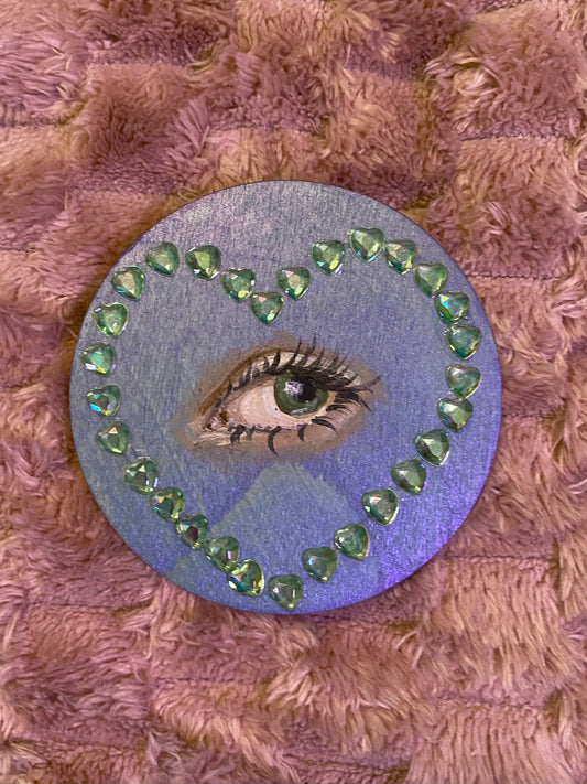 blue round magnet with a heart with an eye in the center