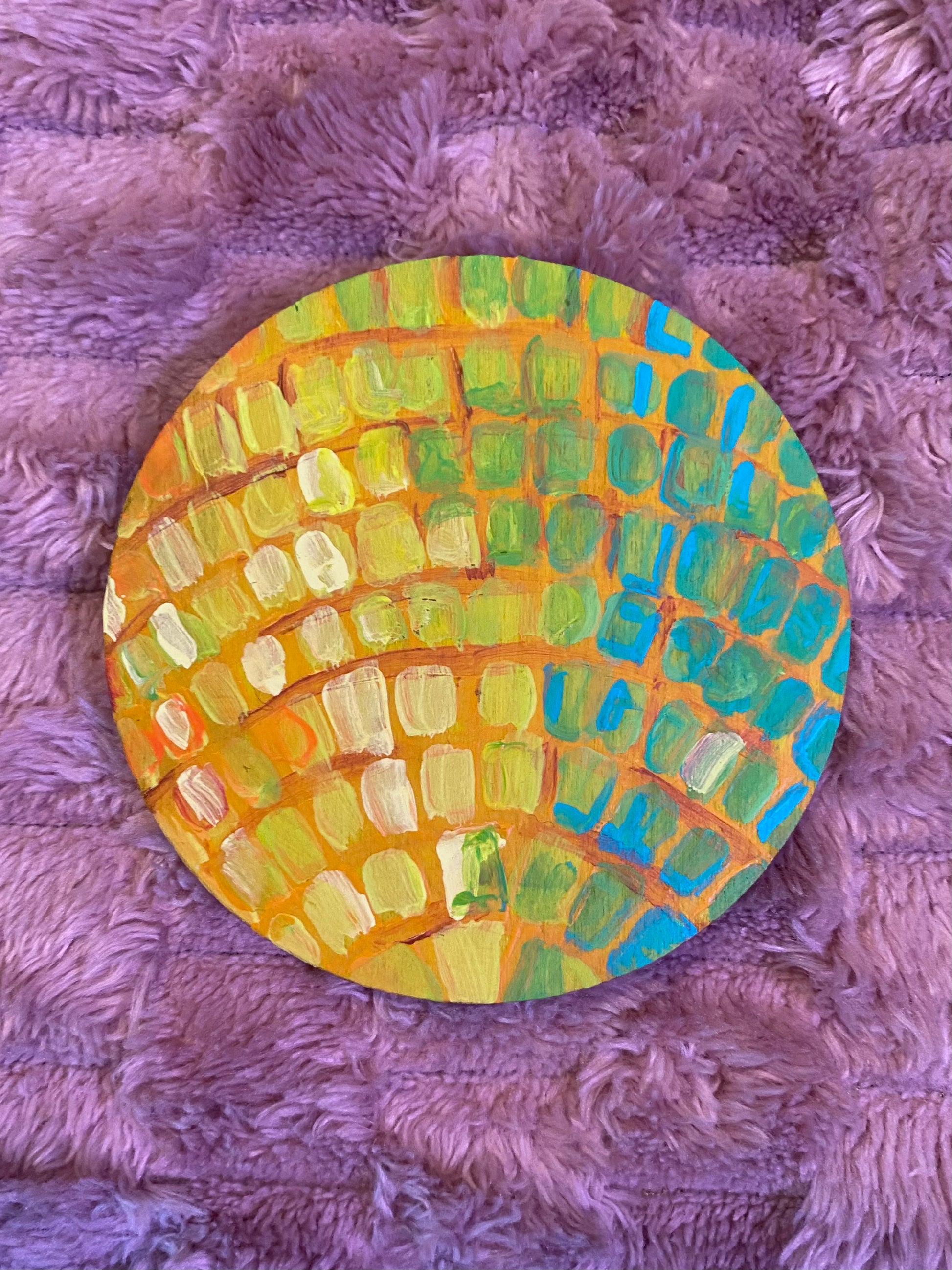 flat round disc with a disco ball painted on it in yellow and green