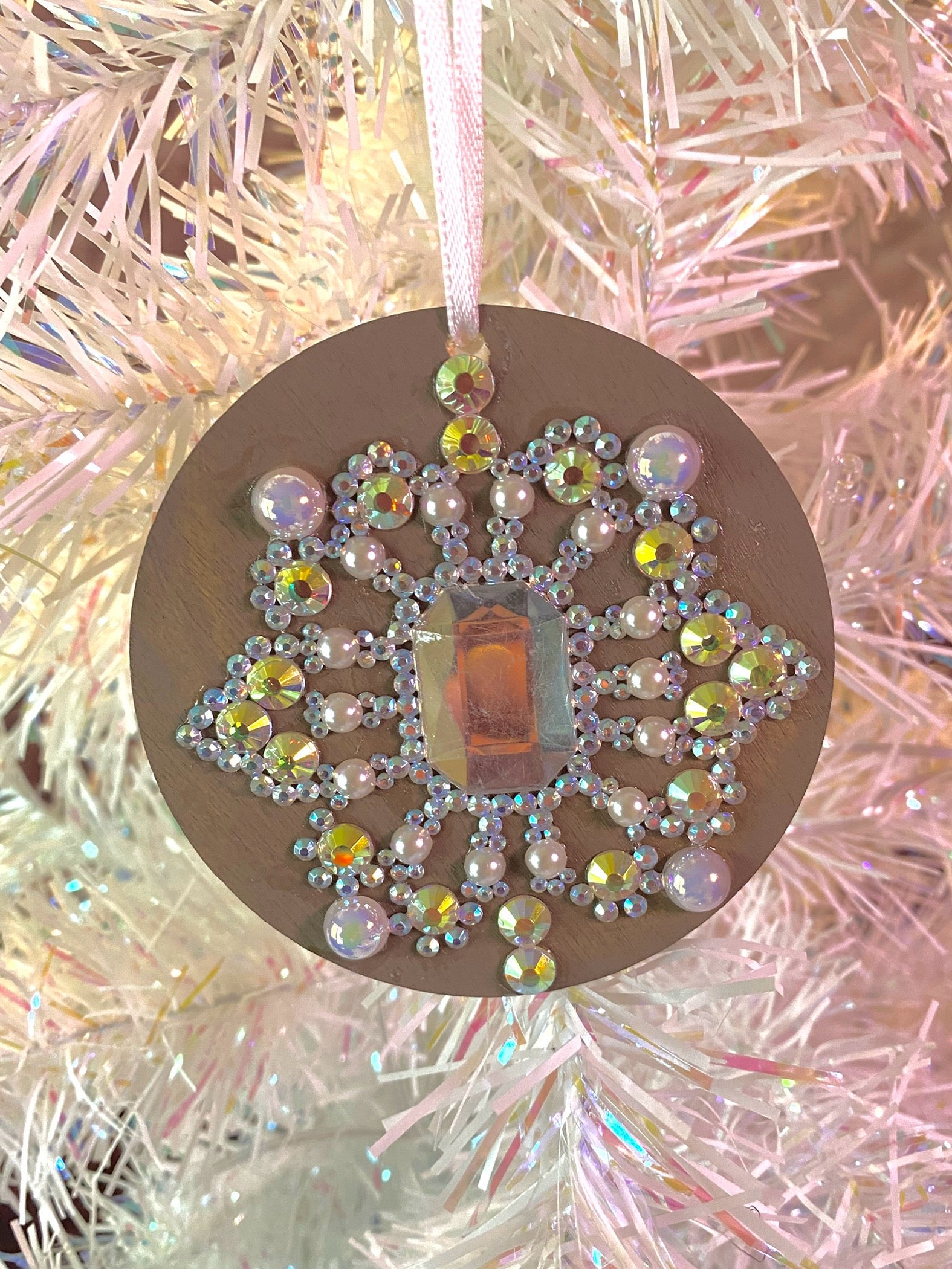 taupe round ornament with multi colored gems, rhinestones, and pearls