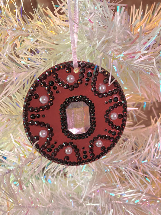 dark red round ornament with small burgundy and black gems